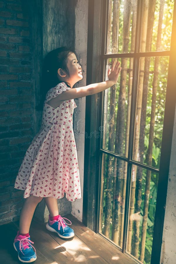 Muchacha asiática con el vestido hermoso que mira la situación de la salida del sol imagen de archivo Muchacha asiática con el vestido hermoso que mira la situación de la salida del sol imagen de archivo