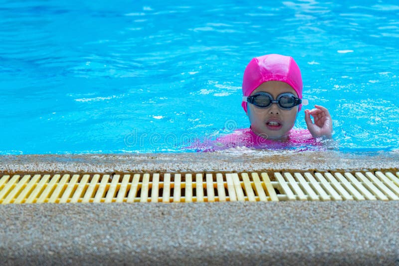 Muchacha asiática del retrato del primer con la habitación que nada y lentes en la piscina fotografía de archivo Muchacha asiática del retrato del primer con la habitación que nada y lentes en la piscina fotografía de archivo