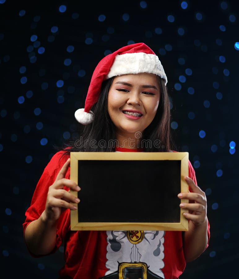 Muchacha asiática feliz que lleva a Santa Costume Christmas Holding Small B fotografía de archivo libre de regalías Muchacha asiática feliz que lleva a Santa Costume Christmas Holding Small B fotografía de archivo libre de regalías