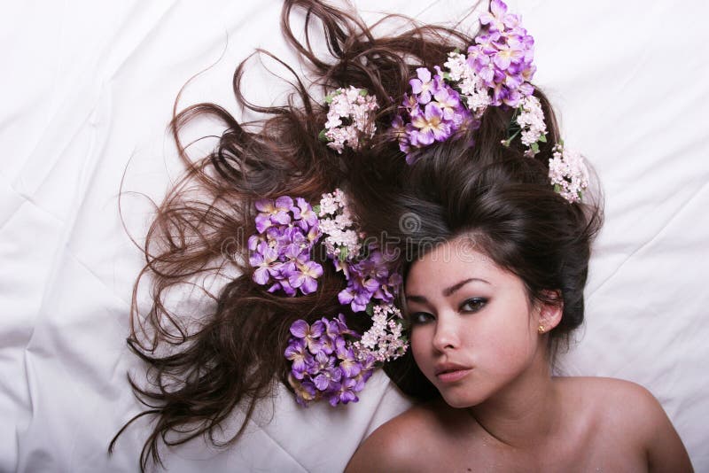 Muchacha asiática hermosa con las flores fotografía de archivo libre de regalías Muchacha asiática hermosa con las flores fotografía de archivo libre de regalías