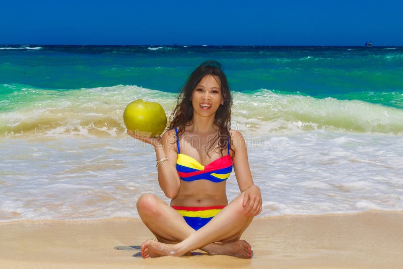 Muchacha asiática hermosa joven con el pelo negro largo en el bikini, drin foto de archivo libre de regalías Muchacha asiática hermosa joven con el pelo negro largo en el bikini, drin foto de archivo libre de regalías