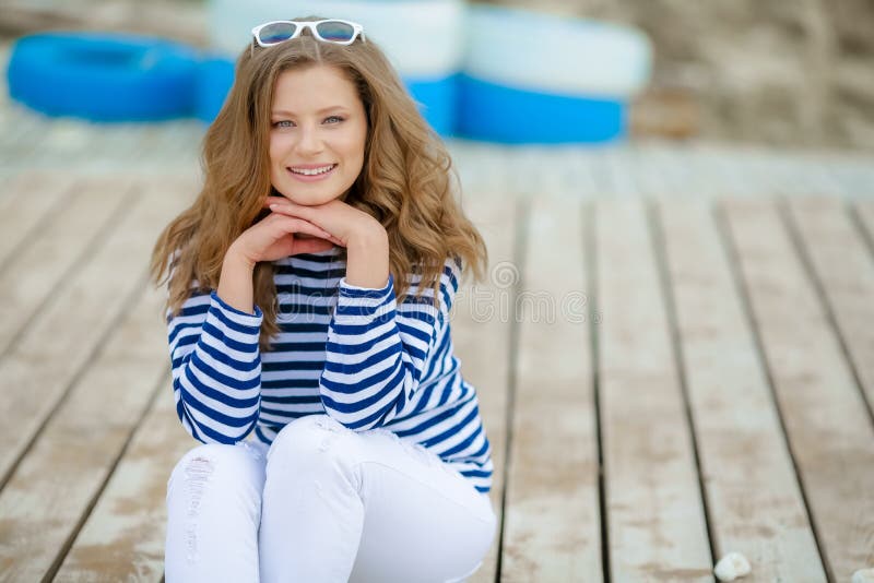 Muchacha atractiva con el pelo rubio largo que presenta juguetónamente después de paseo alrededor de parque Señora encantadora en foto de archivo Muchacha atractiva con el pelo rubio largo que presenta juguetónamente después de paseo alrededor de parque Señora encantadora en foto de archivo