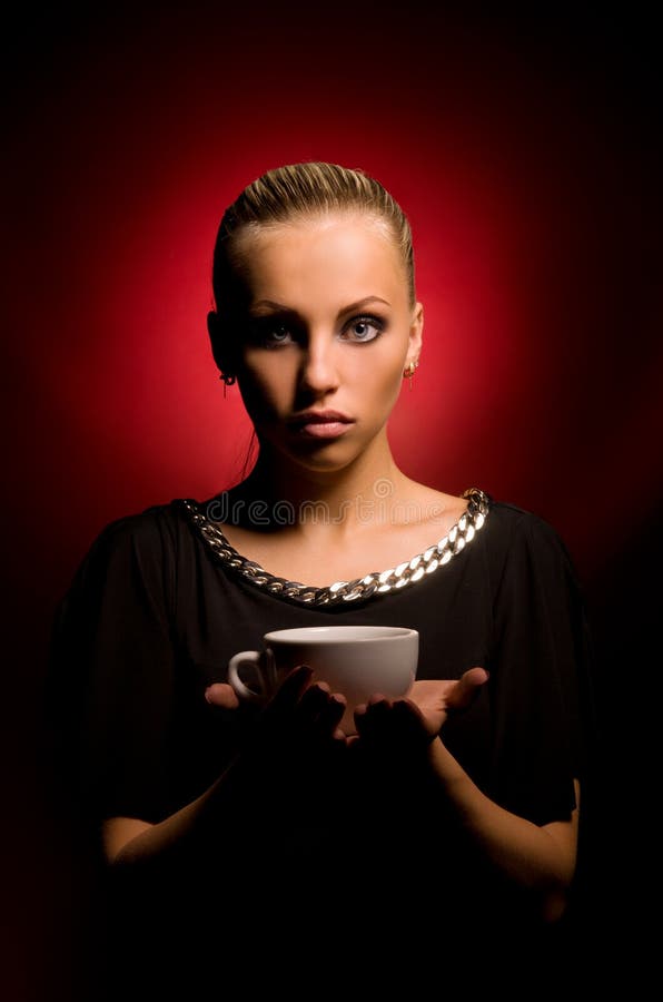 Muchacha atractiva con maquillaje agresivo y la taza blanca fotografía de archivo Muchacha atractiva con maquillaje agresivo y la taza blanca fotografía de archivo