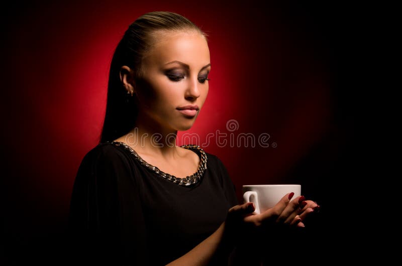 Muchacha atractiva con maquillaje agresivo y la taza blanca imagen de archivo Muchacha atractiva con maquillaje agresivo y la taza blanca imagen de archivo
