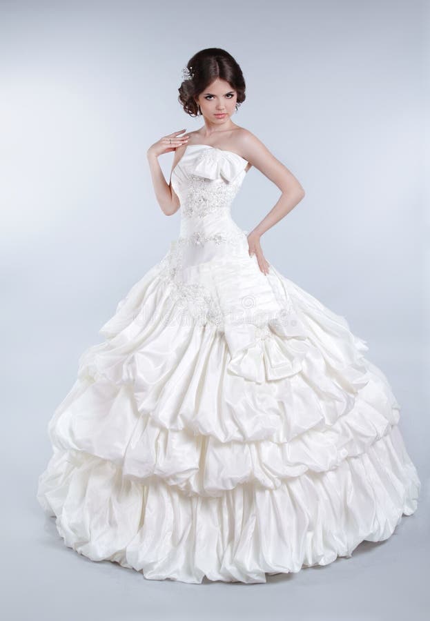 Muchacha atractiva del modelo de la novia que lleva en vestido de boda con volumi
