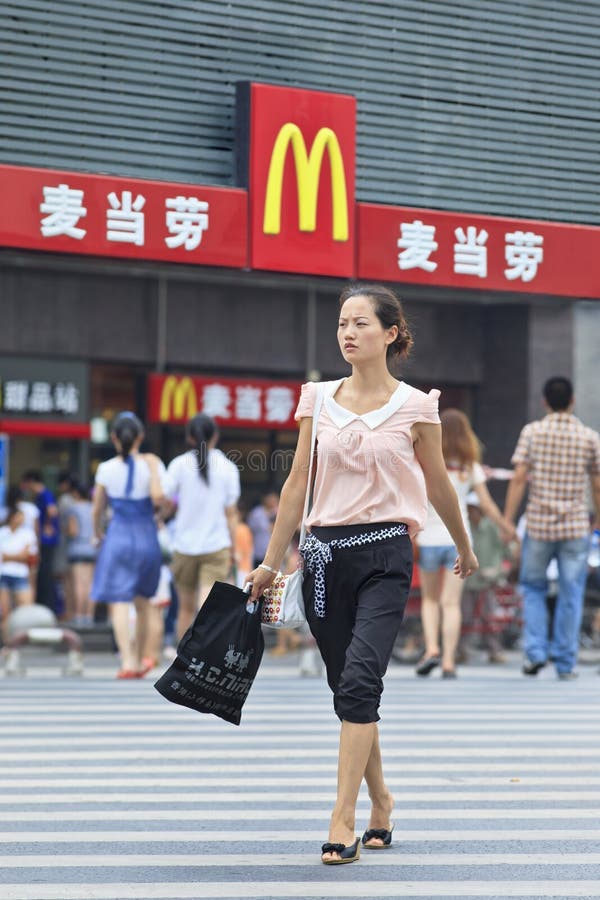 XIANG YANG-CHINA-JULY 3, 2012. Pretty girl walks in front of McDonald. It took McDonald 19 years to reach 1,000 restaurants in China. It plans to raise it to 2,000 by 2013. Xiang Yang, July 3, 2012. XIANG YANG-CHINA-JULY 3, 2012. Pretty girl walks in front of McDonald. It took McDonald 19 years to reach 1,000 restaurants in China. It plans to raise it to 2,000 by 2013. Xiang Yang, July 3, 2012