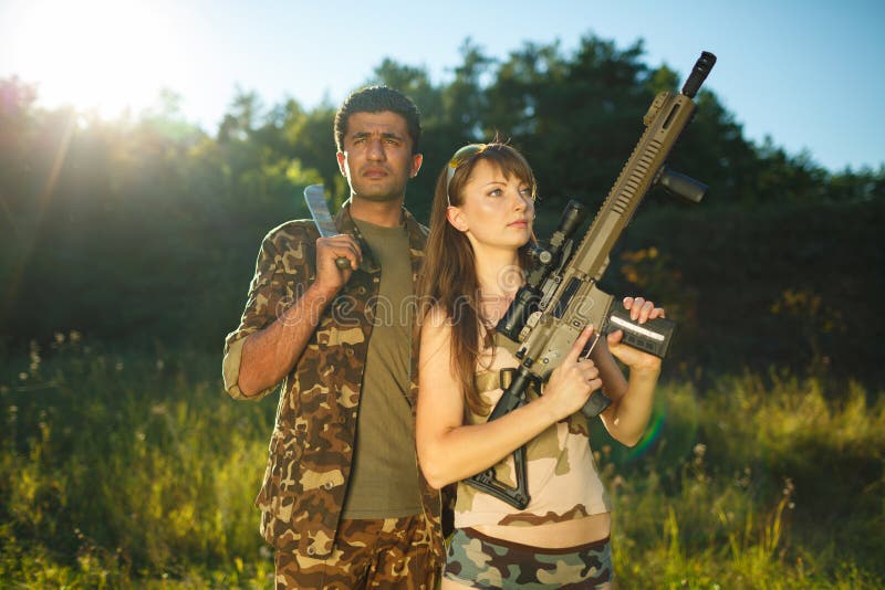 Muchacha blanca y un hombre árabe en camuflaje con un arma en la ha imagen de archivo