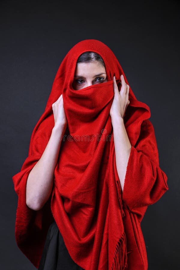 Muchacha caucásica cubierta en un poncho rojo foto de archivo libre de regalías Muchacha caucásica cubierta en un poncho rojo foto de archivo libre de regalías