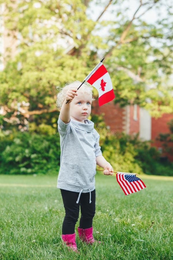 Muchacha caucásica que sostiene y que agita la bandera americana en parque fuera de celebrar concepto del día de la bandera del D foto de archivo Muchacha caucásica que sostiene y que agita la bandera americana en parque fuera de celebrar concepto del día de la bandera del D foto de archivo