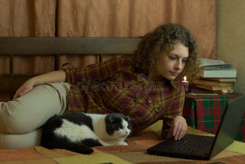 Girl with a cat and a laptop sitting in bed. Girl with a cat and a laptop sitting in bed