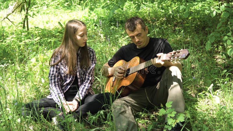 Muchacha con el padre que toca la guitarra imagenes de archivo Muchacha con el padre que toca la guitarra imagenes de archivo