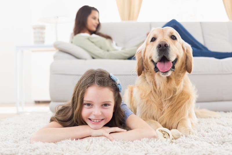 Muchacha con el perro que miente en la manta en casa fotos de archivo libres de regalías Muchacha con el perro que miente en la manta en casa fotos de archivo libres de regalías