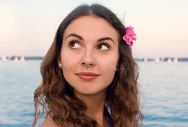 Muchacha con la flor rosada por el agua foto de archivo libre de regalías Muchacha con la flor rosada por el agua foto de archivo libre de regalías