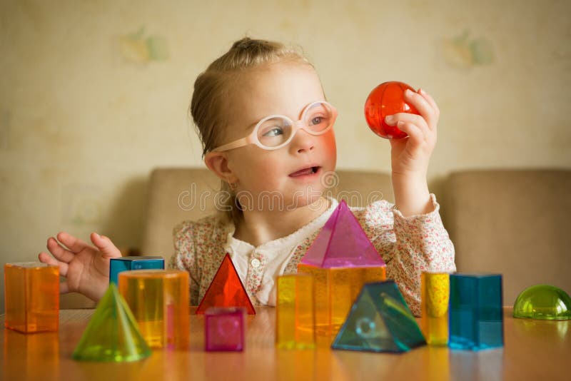 Muchacha con Síndrome de Down que juega con formas geométricas fotografía de archivo libre de regalías Muchacha con Síndrome de Down que juega con formas geométricas fotografía de archivo libre de regalías