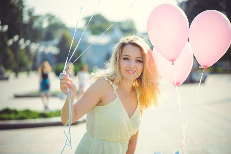 Muchacha de la belleza con los globos coloridos que ríe en una calle de la ciudad Mujer joven feliz hermosa en un día brillante s imágenes de archivo libres de regalías Muchacha de la belleza con los globos coloridos que ríe en una calle de la ciudad Mujer joven feliz hermosa en un día brillante s imágenes de archivo libres de regalías