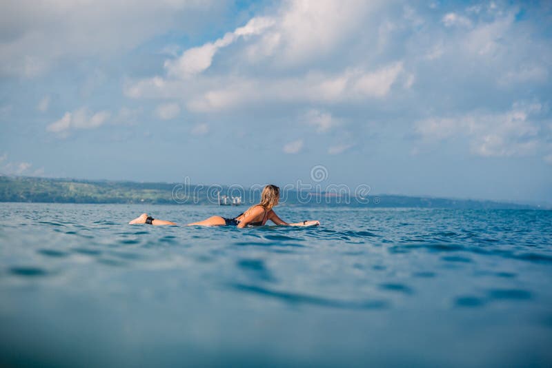 Muchacha de la persona que practica surf en la tabla hawaiana Mujer con la tabla hawaiana en el océano fotografía de archivo libre de regalías Muchacha de la persona que practica surf en la tabla hawaiana Mujer con la tabla hawaiana en el océano fotografía de archivo libre de regalías