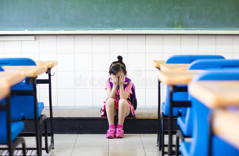 Muchacha de la tensión que se sienta en el piso de la sala de clase fotos de archivo Muchacha de la tensión que se sienta en el piso de la sala de clase fotos de archivo