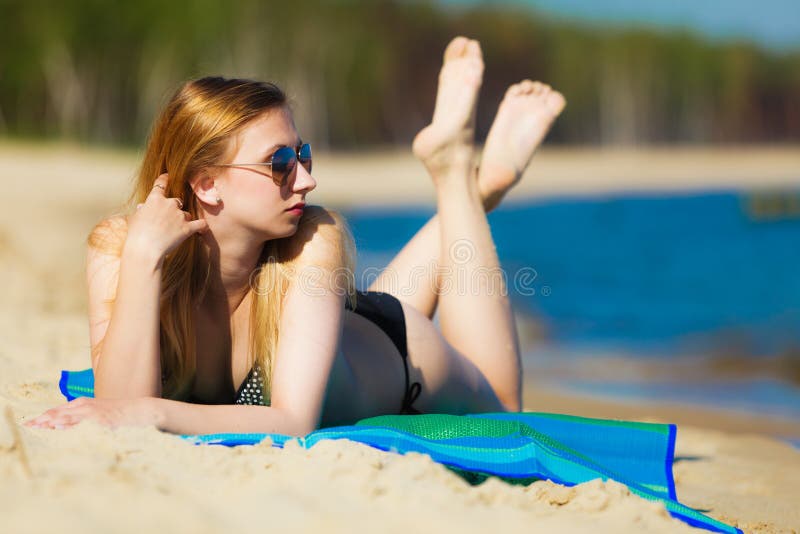 Muchacha de las vacaciones de verano en bikini que toma el sol en la playa fotografía de archivo Muchacha de las vacaciones de verano en bikini que toma el sol en la playa fotografía de archivo