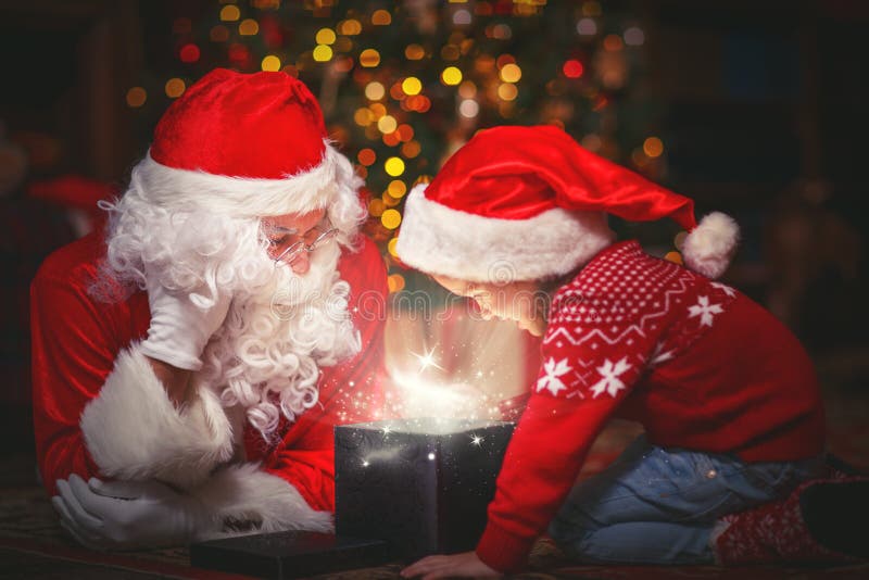 Santa Claus and child girl with bright magical gift in Christmas night. Santa Claus and child girl with bright magical gift in Christmas night