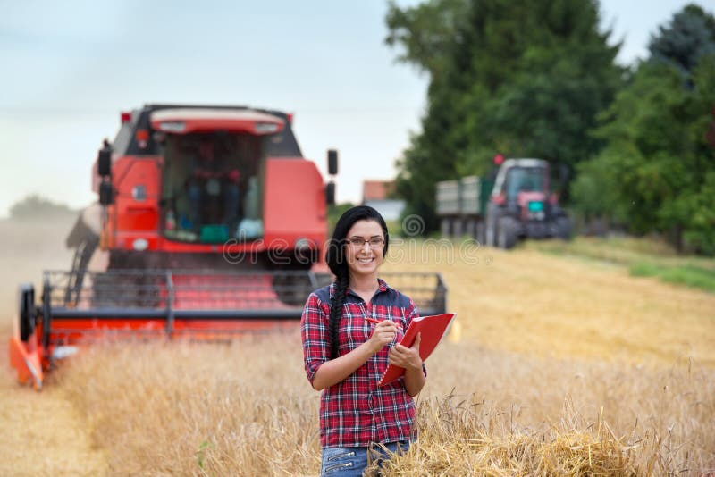 Muchacha del granjero en campo con la máquina segadora foto de archivo Muchacha del granjero en campo con la máquina segadora foto de archivo