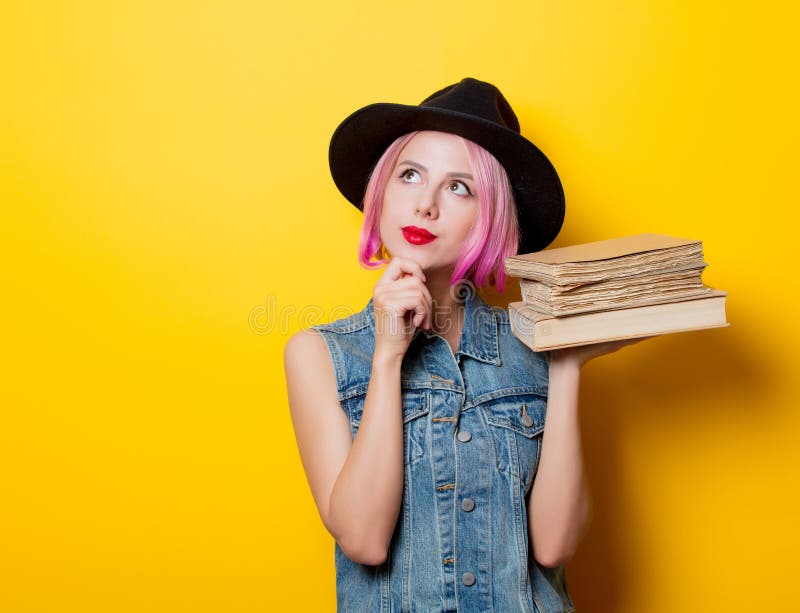 Muchacha del inconformista con el peinado rosado con los libros imágenes de archivo libres de regalías Muchacha del inconformista con el peinado rosado con los libros imágenes de archivo libres de regalías