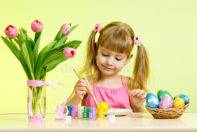 Muchacha del niño con el cepillo que colorea los huevos de Pascua imágenes de archivo libres de regalías Muchacha del niño con el cepillo que colorea los huevos de Pascua imágenes de archivo libres de regalías