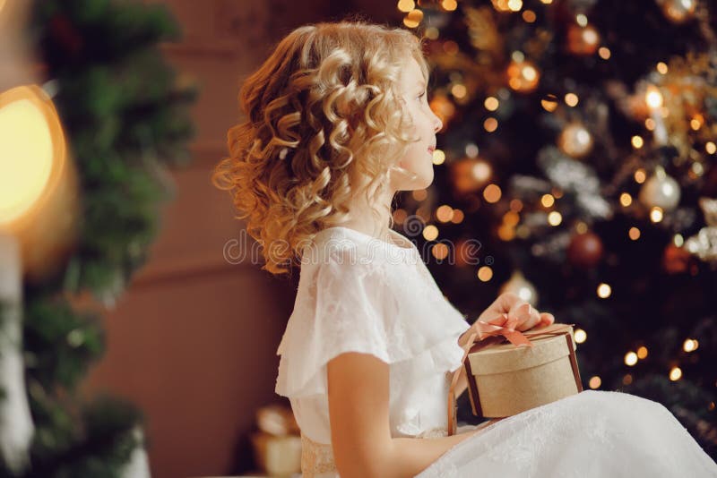 Muchacha del niño en caja de regalo de apertura del Año Nuevo de la Navidad del sombrero de Papá Noel fotografía de archivo libre de regalías Muchacha del niño en caja de regalo de apertura del Año Nuevo de la Navidad del sombrero de Papá Noel fotografía de archivo libre de regalías