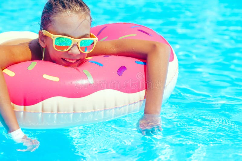 Tween girl relaxing on the donut lilo in resort pool in Thailand. Tween girl relaxing on the donut lilo in resort pool in Thailand