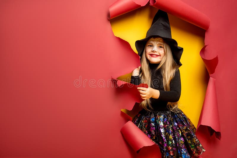 Muchacha divertida de risa del niño en un traje de la bruja en Halloween fotografía de archivo Muchacha divertida de risa del niño en un traje de la bruja en Halloween fotografía de archivo