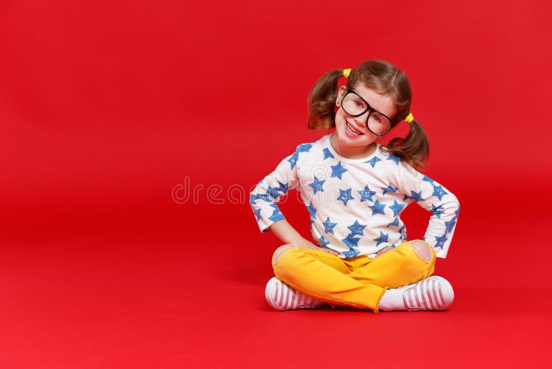 Muchacha divertida del niño en vidrios en fondo coloreado imagenes de archivo Muchacha divertida del niño en vidrios en fondo coloreado imagenes de archivo