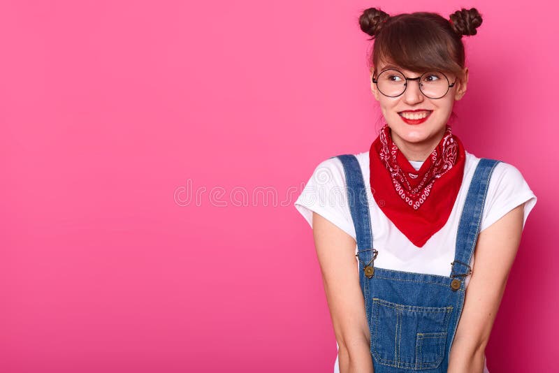 Muchacha dulce sonriente joven que mira a un lado, camiseta blanca casual que lleva, guardapolvos de los vaqueros, pañuelo rojo y imagenes de archivo Muchacha dulce sonriente joven que mira a un lado, camiseta blanca casual que lleva, guardapolvos de los vaqueros, pañuelo rojo y imagenes de archivo