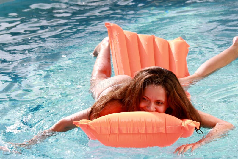 Muchacha en el colchón inflable en la piscina fotografía de archivo libre de regalías Muchacha en el colchón inflable en la piscina fotografía de archivo libre de regalías