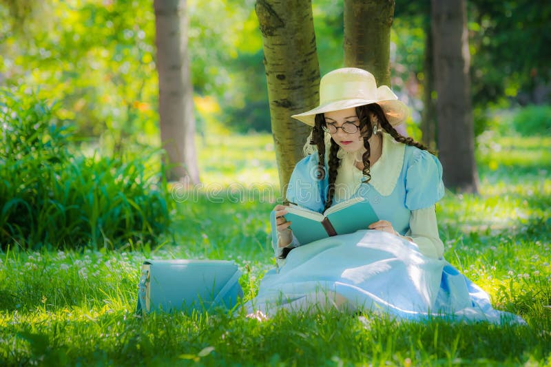 Muchacha en la imagen de la heroína de una hada que se sienta debajo de un árbol imagen de archivo libre de regalías Muchacha en la imagen de la heroína de una hada que se sienta debajo de un árbol imagen de archivo libre de regalías