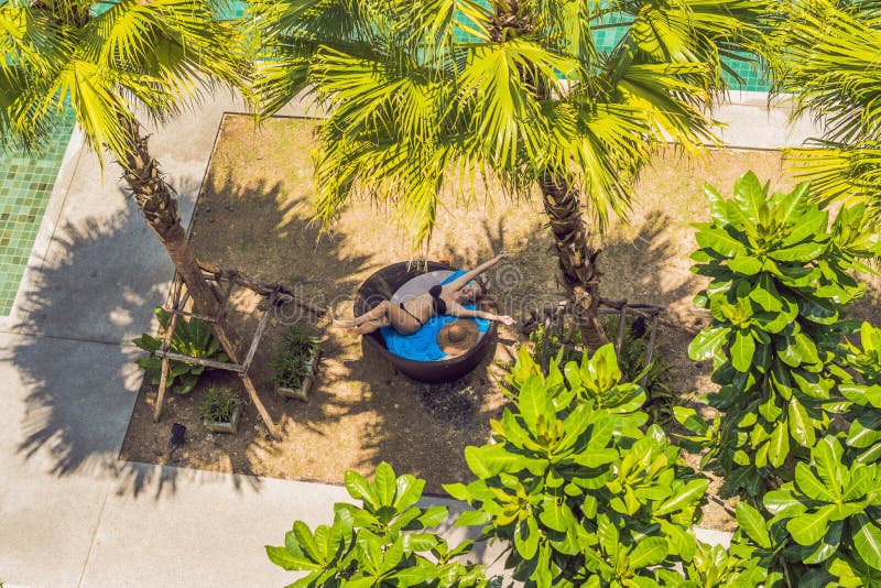 Muchacha en ociosos del sol entre las palmeras cerca de la piscina imágenes de archivo libres de regalías Muchacha en ociosos del sol entre las palmeras cerca de la piscina imágenes de archivo libres de regalías
