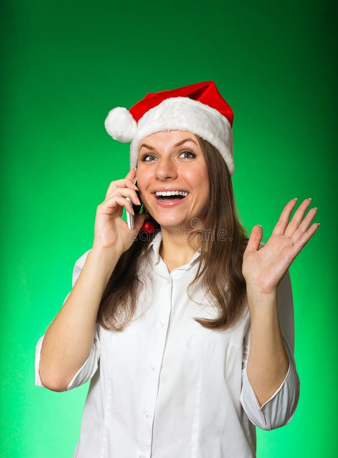 Muchacha en un sombrero de la Navidad en un fondo verde fotos de archivo