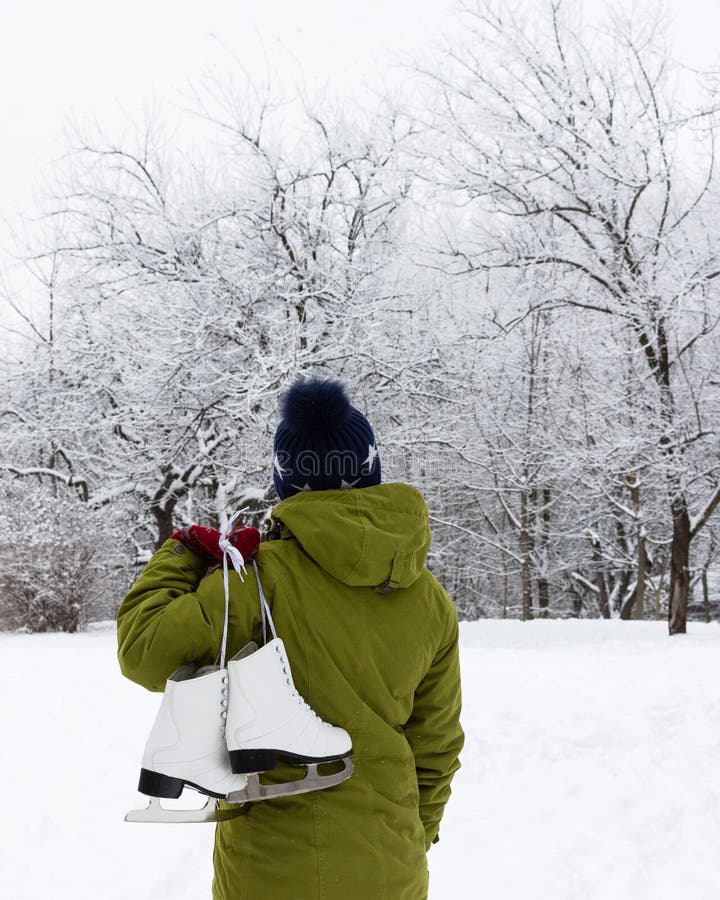Muchacha en una chaqueta verde con los patines de hielo fotografía de archivo libre de regalías Muchacha en una chaqueta verde con los patines de hielo fotografía de archivo libre de regalías