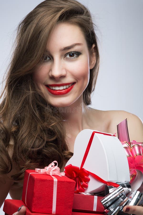 Muchacha en vestido rojo con los regalos el día de tarjetas del día de San Valentín imágenes de archivo libres de regalías Muchacha en vestido rojo con los regalos el día de tarjetas del día de San Valentín imágenes de archivo libres de regalías