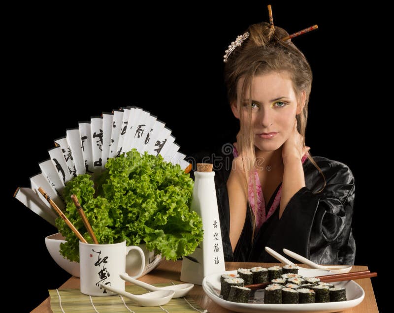 Muchacha encantadora en kimono que come el sushi imagen de archivo Muchacha encantadora en kimono que come el sushi imagen de archivo