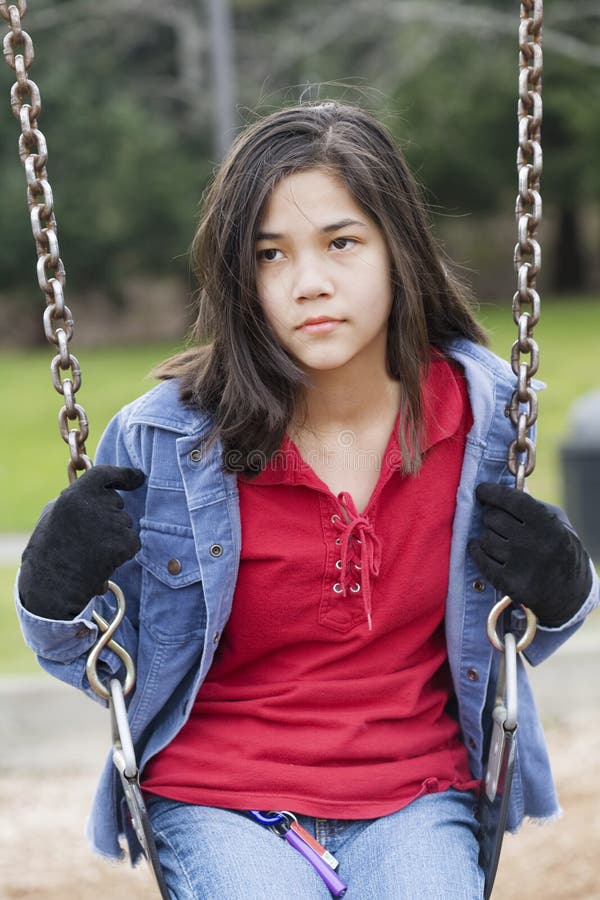 Muchacha enojada, triste del preadolescente en el oscilación imagen de archivo