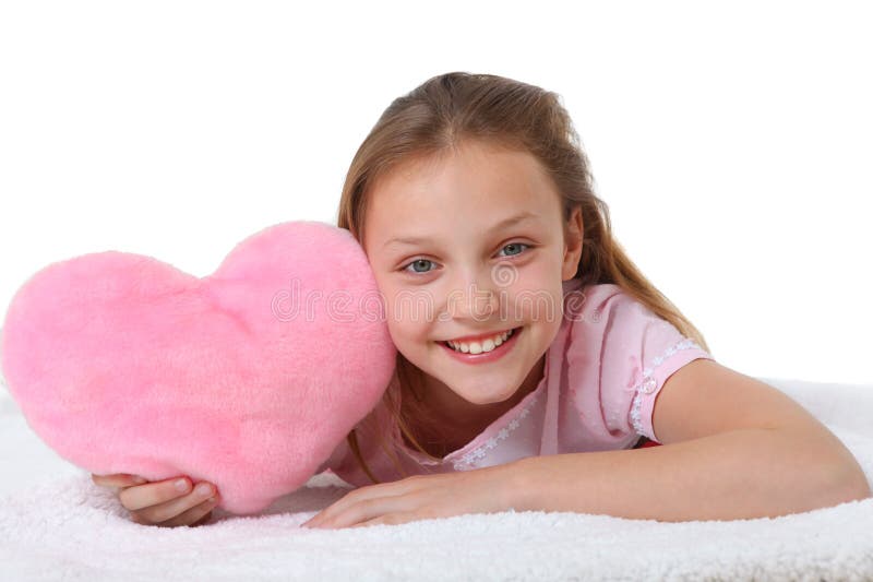 Muchacha feliz con la almohada rosada del corazón fotos de archivo libres de regalías Muchacha feliz con la almohada rosada del corazón fotos de archivo libres de regalías