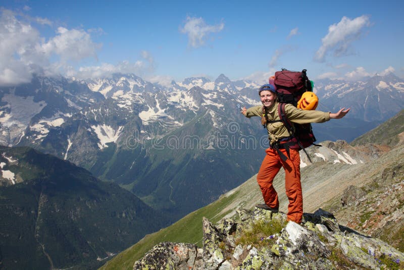 Muchacha feliz del backpacker en montañas