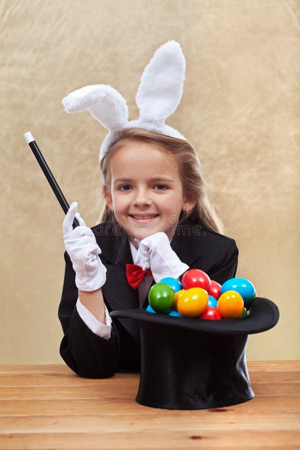 Muchacha feliz del mago que hace los huevos de Pascua con sus poderes fotografía de archivo libre de regalías Muchacha feliz del mago que hace los huevos de Pascua con sus poderes fotografía de archivo libre de regalías