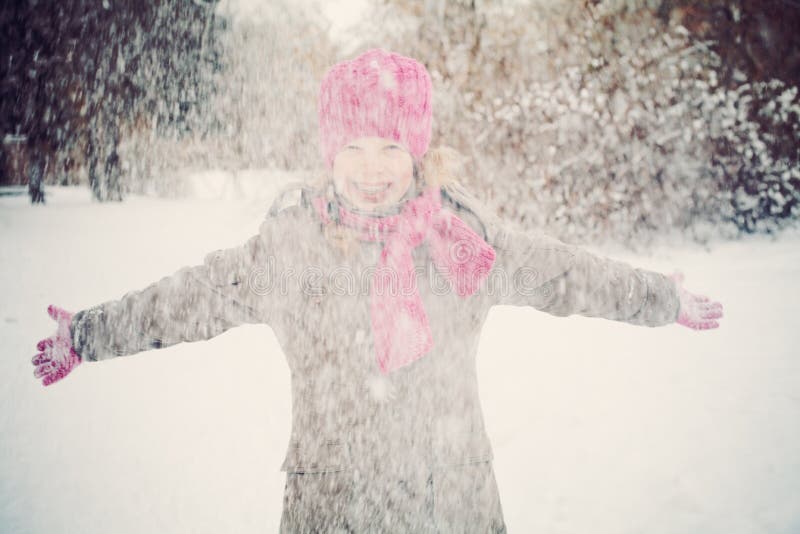 Muchacha feliz del niño que se divierte que juega con nieve imágenes de archivo libres de regalías Muchacha feliz del niño que se divierte que juega con nieve imágenes de archivo libres de regalías