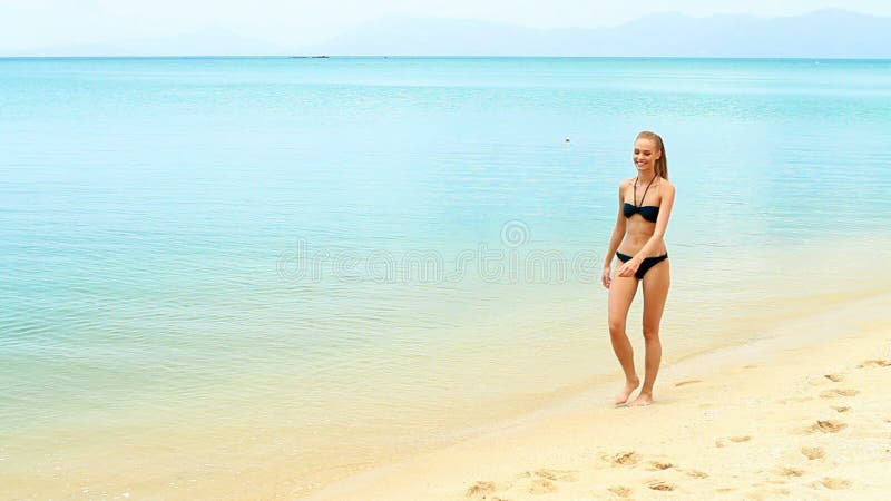 Muchacha feliz joven que camina en la playa