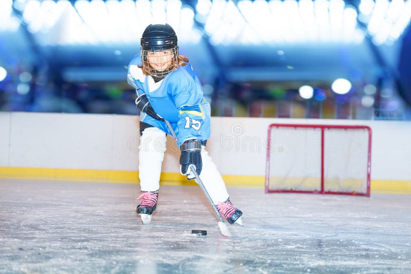 Muchacha feliz que pasa el duende malicioso durante juego de hockey foto de archivo Muchacha feliz que pasa el duende malicioso durante juego de hockey foto de archivo