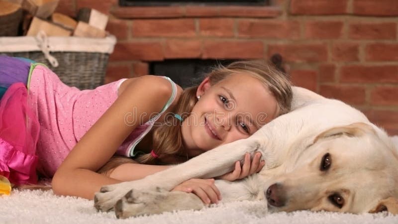 Muchacha feliz que se relaja con su perro