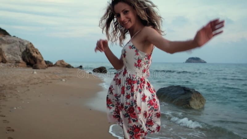 Muchacha feliz sonriente hermosa joven que camina en la playa