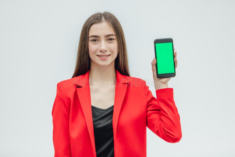 Muchacha guapita de cara joven que lleva una chaqueta roja r Durante este tiempo, sosteniendo un teléfono negro con imagen de archivo libre de regalías Muchacha guapita de cara joven que lleva una chaqueta roja r Durante este tiempo, sosteniendo un teléfono negro con imagen de archivo libre de regalías