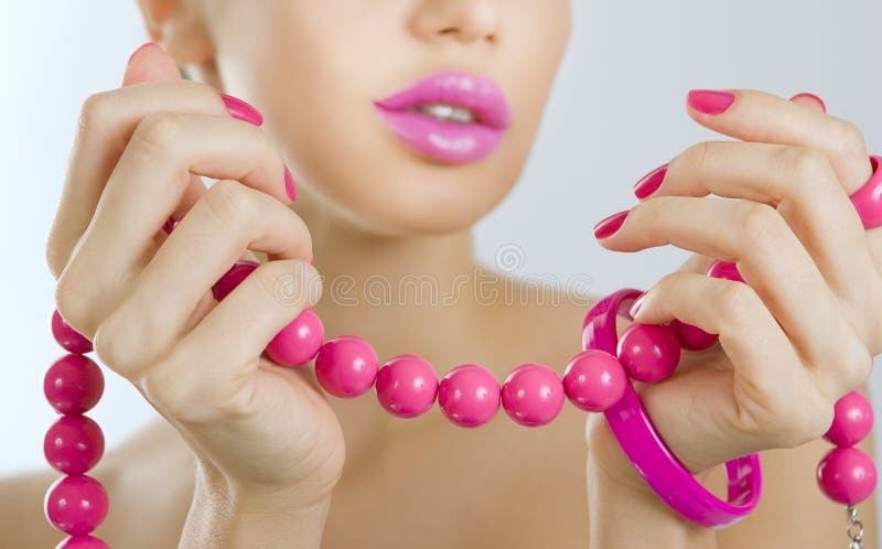 Muchacha hermosa con ascendente cercano rosado brillante de la manicura y del accesorio