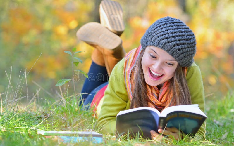 Beautiful young woman reading a book in autumn day. Beautiful young woman reading a book in autumn day